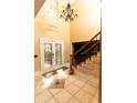 Elegant foyer featuring soaring ceilings, decorative tile flooring, and a grand staircase with chandelier at 1770 Nordic Ct, Apopka, FL 32712