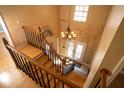 Staircase with wood treads and black iron balusters leading to upper level, with a chandelier overhead at 1770 Nordic Ct, Apopka, FL 32712
