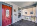 Close up of a front porch with a red door, hanging lantern, and swing at 1900 Garvin St, Orlando, FL 32803