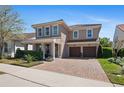 Attractive two-story house with a paver driveway leading to a two-car garage and a landscaped front yard at 2724 Sarzana Ln, Apopka, FL 32712