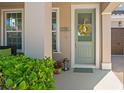 Inviting front entrance featuring a decorative wreath, lantern, potted plants, and the house number display at 2724 Sarzana Ln, Apopka, FL 32712