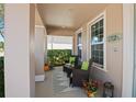 Cozy covered porch with comfortable seating, decorative plants, and a view of the manicured front yard at 2724 Sarzana Ln, Apopka, FL 32712