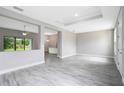 Spacious living room featuring hard surface floors, tray ceiling, and neutral paint at 30340 W Bluebell Ave, Eustis, FL 32736