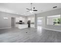 Open-concept living space with sleek flooring connecting the kitchen and living areas at 30340 W Bluebell Ave, Eustis, FL 32736