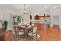Dining room with wood floors, chandelier, and sliding glass doors to the outside patio at 381 Corbett Dr, The Villages, FL 32162