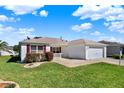 A charming one-story home with manicured lawn and red shutters offers curb appeal at 381 Corbett Dr, The Villages, FL 32162