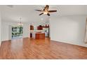 Open-concept living space featuring wood floors that connects seamlessly to the kitchen at 381 Corbett Dr, The Villages, FL 32162