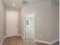 Bright entryway featuring wood-look flooring, neutral walls, and doorway into bedroom at 4198 Sw 128Th Pl, Ocala, FL 34473