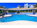 Outdoor community pool featuring a tanning deck, ample seating, and a charming open air cabana at 5300 S Atlantic Ave # 7-301, New Smyrna Beach, FL 32169