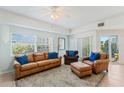 Cozy living room featuring leather furniture, a large window, and access to the balcony at 5300 S Atlantic Ave # 7-301, New Smyrna Beach, FL 32169