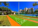 A recreational shuffleboard area, with a tennis court, landscaping and residential building in the background at 5300 S Atlantic Ave # 7-301, New Smyrna Beach, FL 32169