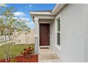 Inviting front entrance with a solid wood door, sidelight window, and neatly landscaped garden at 600 Bullrush Ct, Davenport, FL 33837