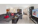 Open-concept living area featuring comfortable seating, a large TV, and seamless access to the kitchen at 600 Bullrush Ct, Davenport, FL 33837