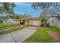 Charming yellow home with well-maintained lawn, brick accents, and convenient driveway access at 818 Alabama Ave, St Cloud, FL 34769