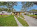 Charming yellow home with well-maintained lawn, brick accents, and convenient driveway access at 818 Alabama Ave, St Cloud, FL 34769