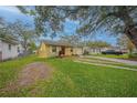 Charming yellow home with well-maintained lawn, brick accents, and convenient driveway access at 818 Alabama Ave, St Cloud, FL 34769