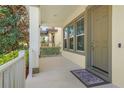 A cozy and inviting covered front porch with white columns, rug, and gray trim around the windows at 8321 Bryce Canyon Ave, Windermere, FL 34786