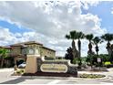 The Champions Club community entrance sign with manicured landscaping and beautiful cloudscape at 8923 Azalea Sands Ln, Davenport, FL 33896