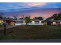Charming single-story home featuring a well-maintained lawn at dusk under a colorful sky at 8960 Se 88Th Pl, Ocala, FL 34472
