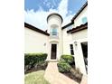 Close up of the home's front entrance and yard, with cylindrical tower on the left at 9207 Busaco Park Way, Winter Garden, FL 34787