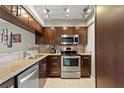 Modern kitchen with stainless steel appliances, granite countertops, and dark wood cabinets at 974 E Michigan St # 974, Orlando, FL 32806