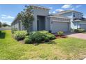 Single-story house with a well-maintained lawn, landscaping, and brick driveway at 1009 Hendon Loop, Davenport, FL 33837