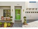 Close-up of modern home's entrance, showcasing a vibrant green door and elegant landscaping at 1018 Stetson St, Orlando, FL 32804