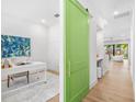 Bright hallway with a green sliding door that opens to an office space at 1018 Stetson St, Orlando, FL 32804