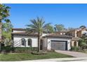 Single-Gathering home shows neutral paint, gray garage door, well-manicured lawn and paver driveway at 1377 Tappie Toorie Cir, Lake Mary, FL 32746