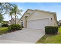 Exterior front view of home featuring a manicured lawn and two-car garage at 155 Barefoot Beach Way, Kissimmee, FL 34746