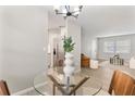 Bright dining area featuring a glass-top table with modern chandelier and stainless steel appliances nearby at 1920 E Edgewood Dr # A5, Lakeland, FL 33803