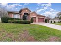 Inviting single-Gathering house featuring lush green grass and a prominent three-car garage at 2029 Majestic Elm Blvd, Ocoee, FL 34761