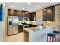 Modern kitchen with dark wood cabinetry, stainless steel appliances, and granite countertops at 2165 Leather Fern Dr, Ocoee, FL 34761