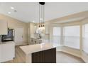 Open kitchen boasts a central island, modern pendant lighting, and stainless steel appliances at 237 Clarinet Way, Davenport, FL 33896