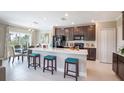 Open kitchen features a large island with seating, dark wood cabinets, and stainless steel appliances at 2743 San Marco Way, Winter Haven, FL 33884