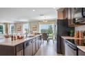 Modern kitchen boasts an island, stainless steel appliances, dark wood cabinets, and an adjacent dining area at 2743 San Marco Way, Winter Haven, FL 33884