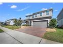 Charming two-story home boasts a well-manicured lawn and a brick-paved driveway at 3005 Slough Creek Dr, Kissimmee, FL 34744