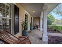 Inviting front porch with rocking chairs, stylish planters, and classic columns at 31707 Orange St, Sorrento, FL 32776