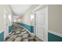 Hallway with neutral paint, contrasting trim, and patterned carpet provides a clean, stylish walkway at 322 E Central Blvd # 606, Orlando, FL 32801