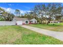 Quaint one-story home with a large front yard, driveway, and a red entry door at 3357 Shalimar Cir, Deltona, FL 32738