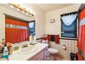 Bathroom featuring tiled walls, vanity, mirror, toilet, and orange shower curtain at 3708 Pipes O The Glen Way, Orlando, FL 32808