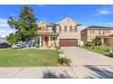 Charming two-story home featuring a well-manicured lawn, inviting orange door, and an attached garage at 4655 Ross Lanier Ln, Kissimmee, FL 34758