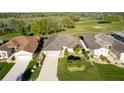 Beautiful aerial view of a home with a lush green lawn, palm trees, and a view of a nearby golf course at 5025 St Andrews Arc, Leesburg, FL 34748