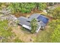 An aerial view of a single Gathering home with a screened in porch and solar panels at 5374 Crooked Oak Cir, St Cloud, FL 34771