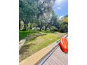 Spacious, grassy backyard with mature trees and waterfront access and an orange kayak at 5374 Crooked Oak Cir, St Cloud, FL 34771