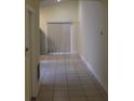 Bright hallway featuring tile flooring and natural light from the sliding glass doors at 6321 Redwood Oaks Dr, Orlando, FL 32818