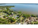 An aerial view displays waterfront neighborhood, with a backdrop of a large lake and mature trees at 6424 Jenny Dr, Lake Wales, FL 33898