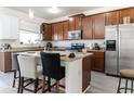 Open kitchen with stainless steel appliances, granite countertops, and a center island with seating at 7407 Ripplepointe Way, Windermere, FL 34786
