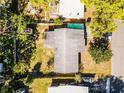 Aerial view shows the home's roof, yard with trees, shed, and surroundings at 818 Logan Dr, Longwood, FL 32750