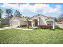 Inviting home showcasing a lush lawn and a welcoming front porch with seating area at 872 High Pointe Cir, Minneola, FL 34715